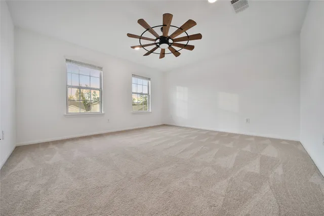 an empty room with window and a ceiling fan