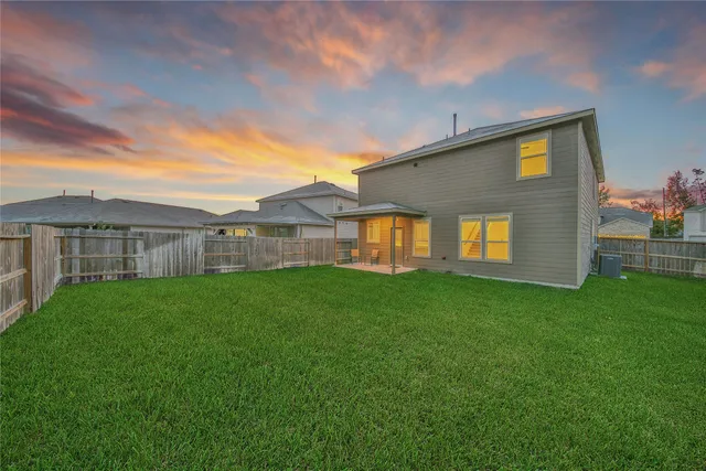 a view of a backyard with plants and large trees