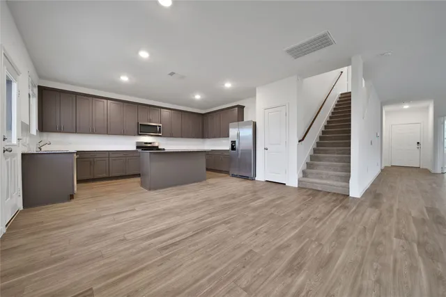 a view of kitchen with wooden floor and electronic appliances