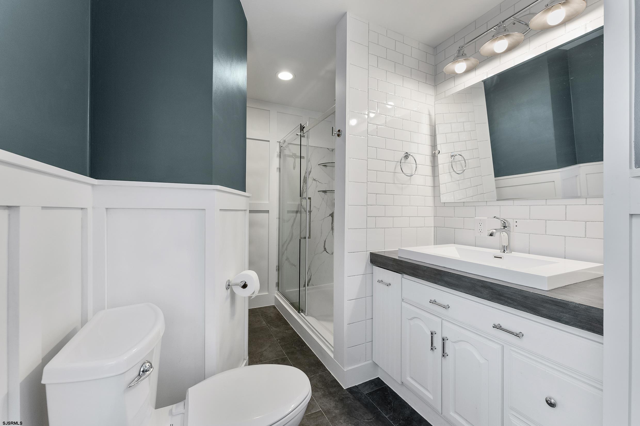 305 East Ridgewood Avenue Galloway Township, NJ 08205 - Photo 25 of 54 a bathroom with a toilet sink and mirror