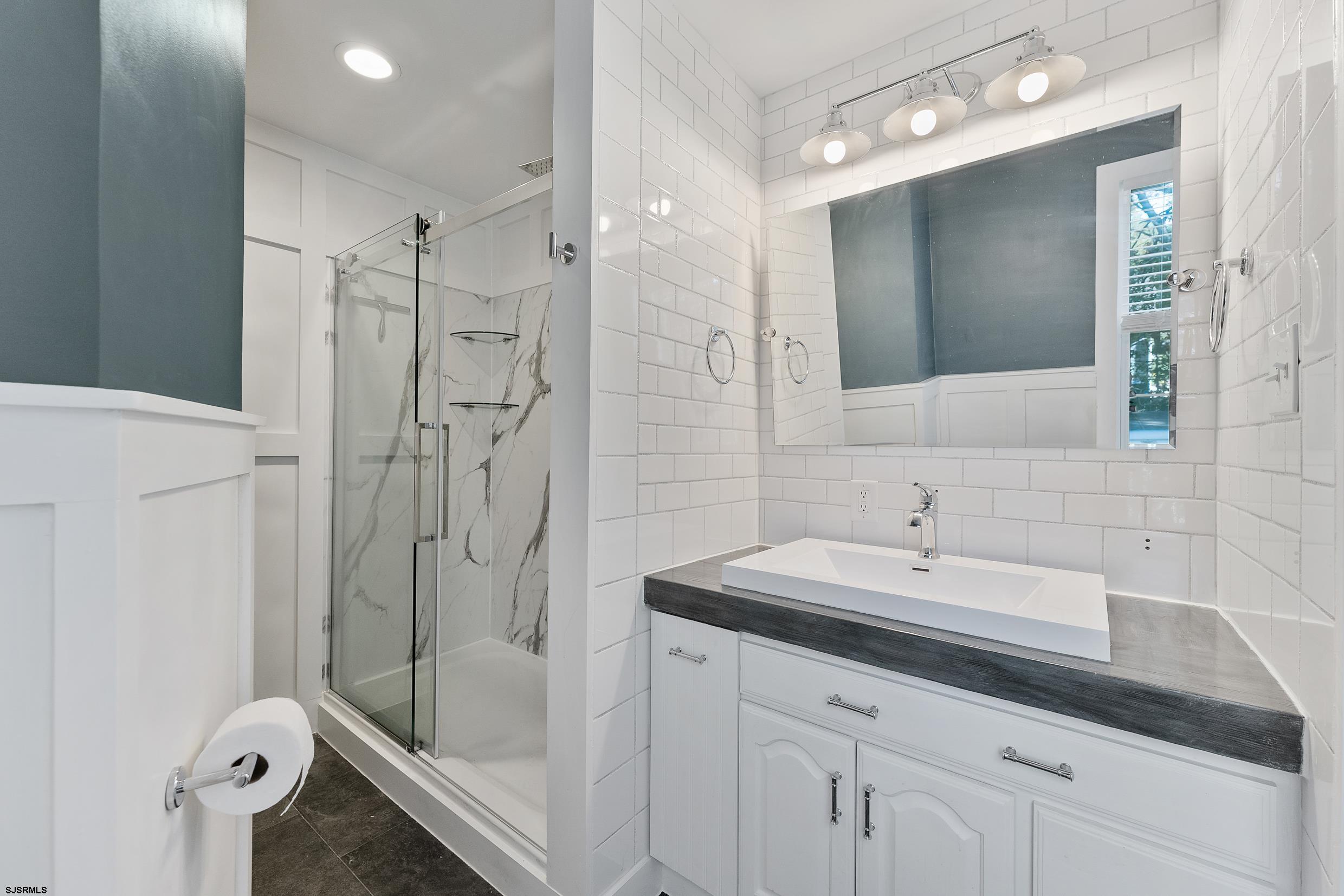 305 East Ridgewood Avenue Galloway Township, NJ 08205 - Photo 26 of 54 a bathroom with a sink tub vanity and a mirror