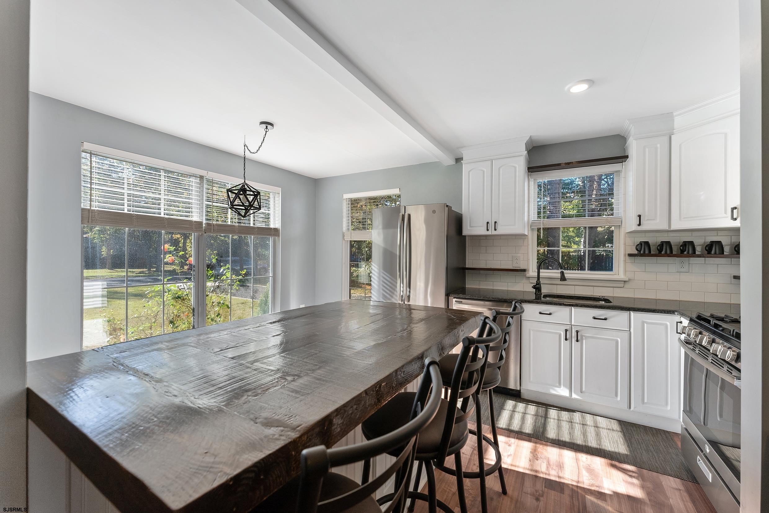 305 East Ridgewood Avenue Galloway Township, NJ 08205 - Photo 8 of 54 a kitchen with granite countertop a table chairs sink and cabinets