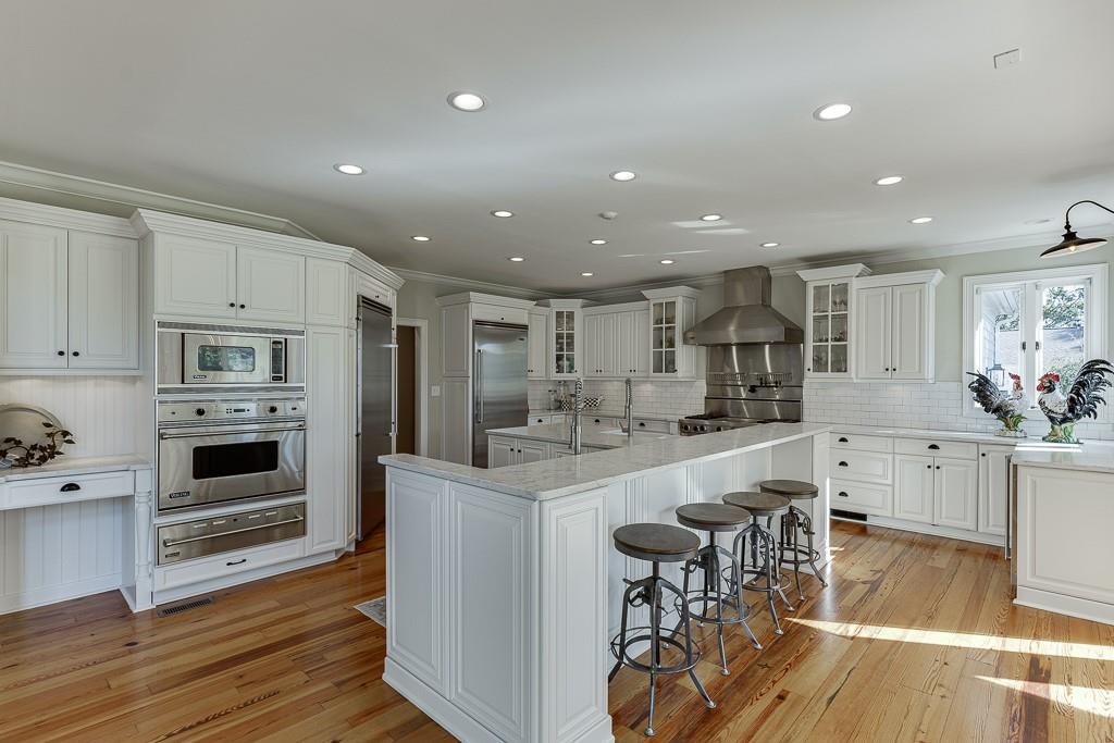986 Austin Road Winder, GA 30680 - Photo 22 of 135 a kitchen with stainless steel appliances granite countertop a stove top oven a sink dishwasher and a refrigerator with wooden floor