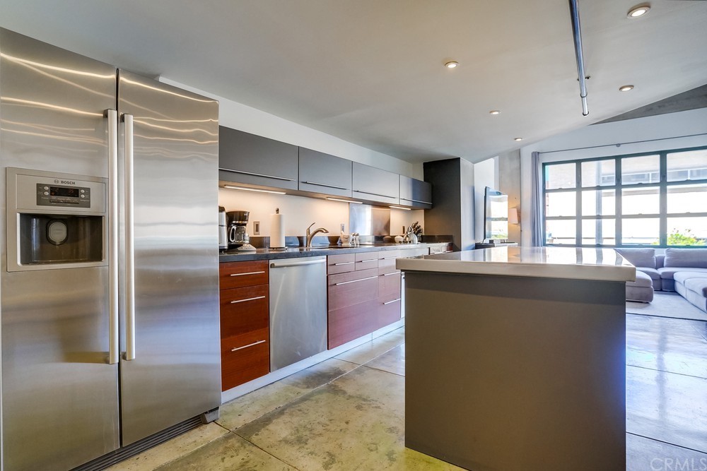 100 West 5th Street Long Beach, CA 90802 - Photo 21 of 53 a kitchen with granite countertop stainless steel appliances cabinets a sink and a large window