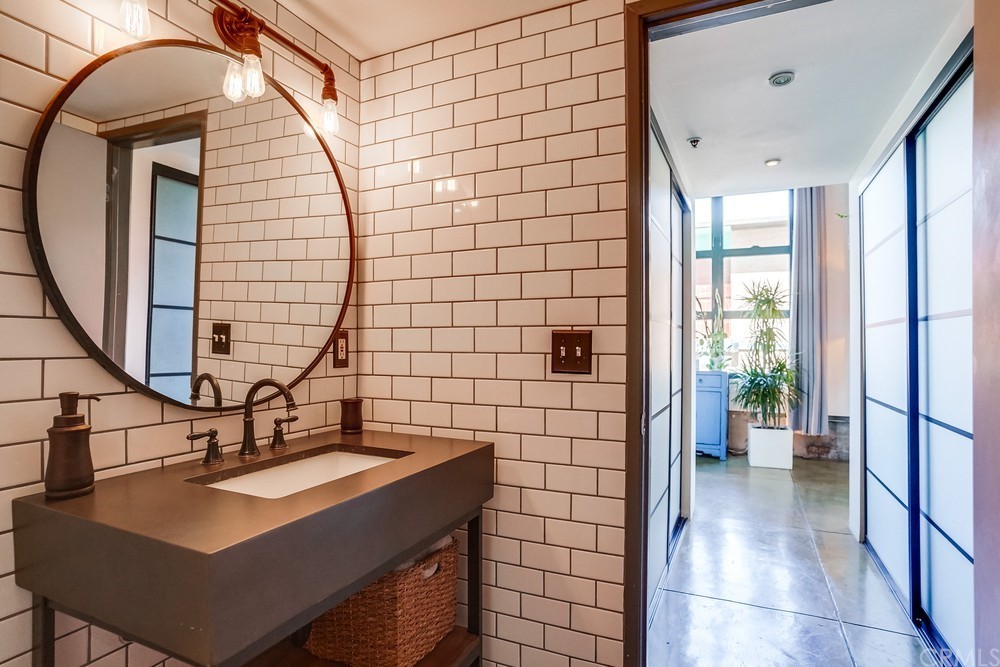 100 West 5th Street Long Beach, CA 90802 - Photo 34 of 53 a bathroom with a sink a mirror and a shower