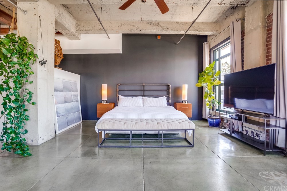 100 West 5th Street Long Beach, CA 90802 - Photo 37 of 53 a spacious bedroom with a bed and a flat screen tv