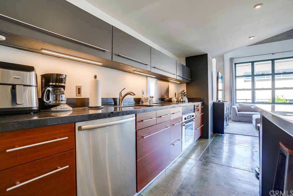 100 West 5th Street Long Beach, CA 90802 - Photo 7 of 53 a kitchen with stainless steel appliances granite countertop a sink and cabinets