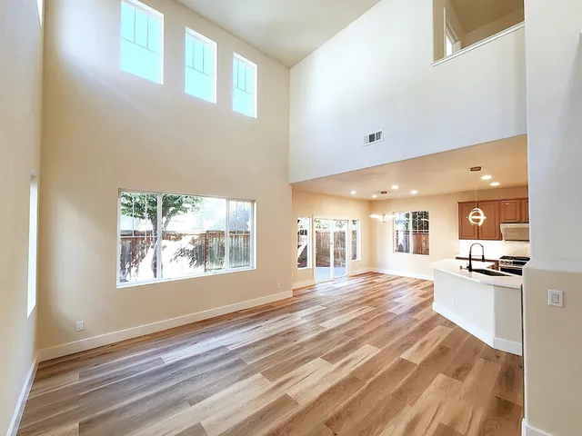 a large hall with windows and view of kitchen