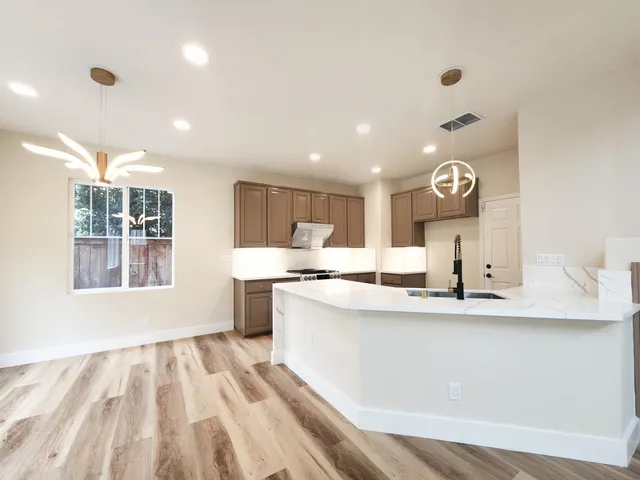 a kitchen with stainless steel appliances granite countertop a sink and a stove top oven