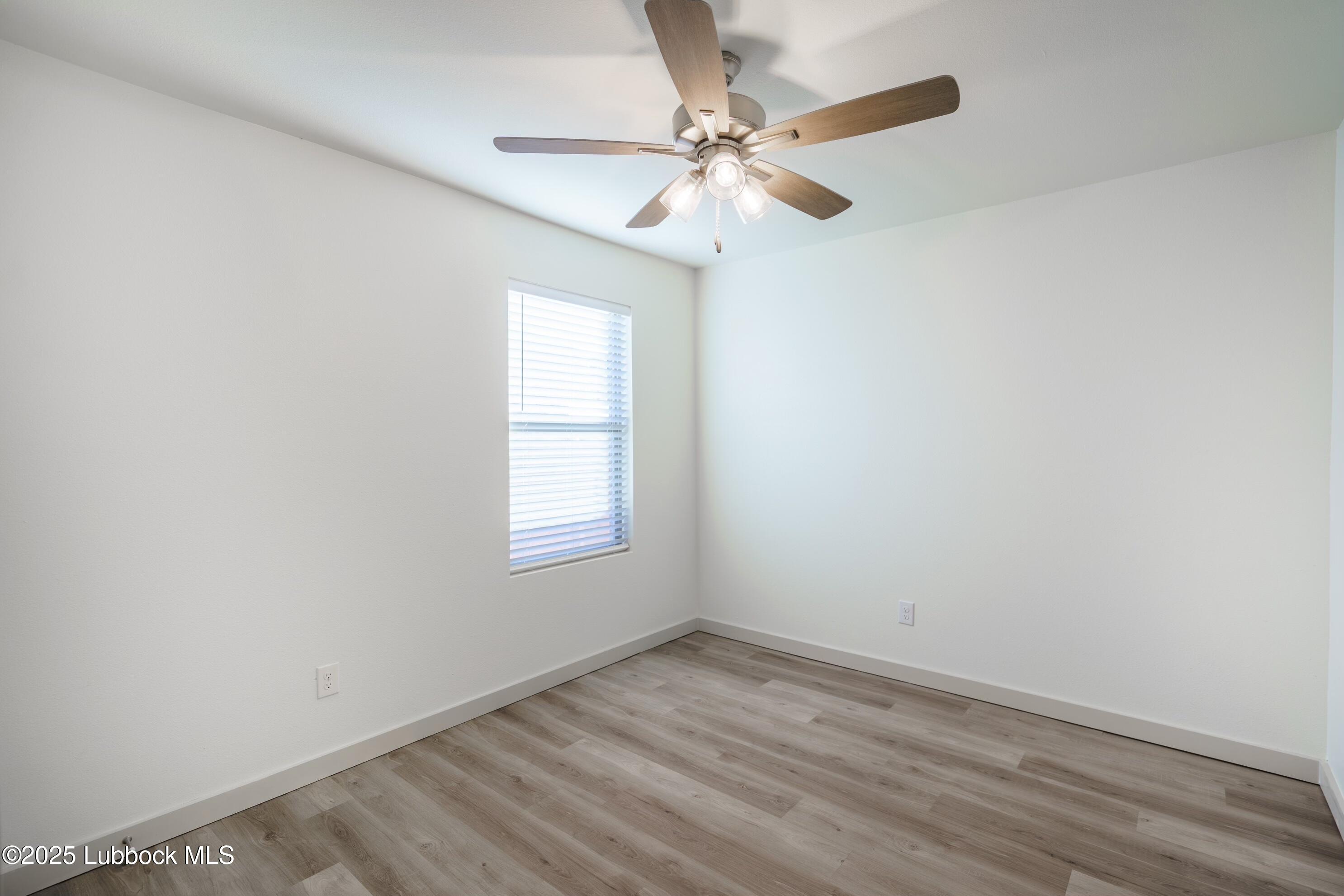 8010 Elm Avenue Lubbock, TX 79404 - Photo 10 of 12 an empty room with a window and a fan