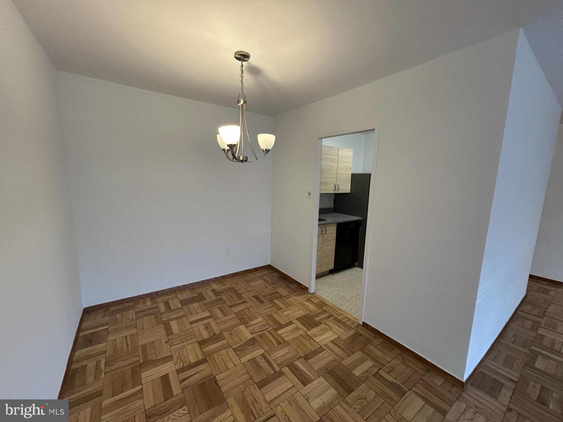 4000 Tunlaw Road Northwest, Unit 223 Washington, DC 20007 - Photo 11 of 28 an empty room with kitchen view and wooden floor