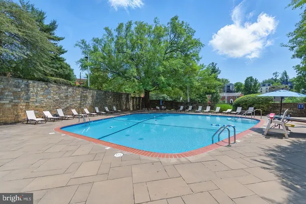 a view of a swimming pool with a patio and a yard