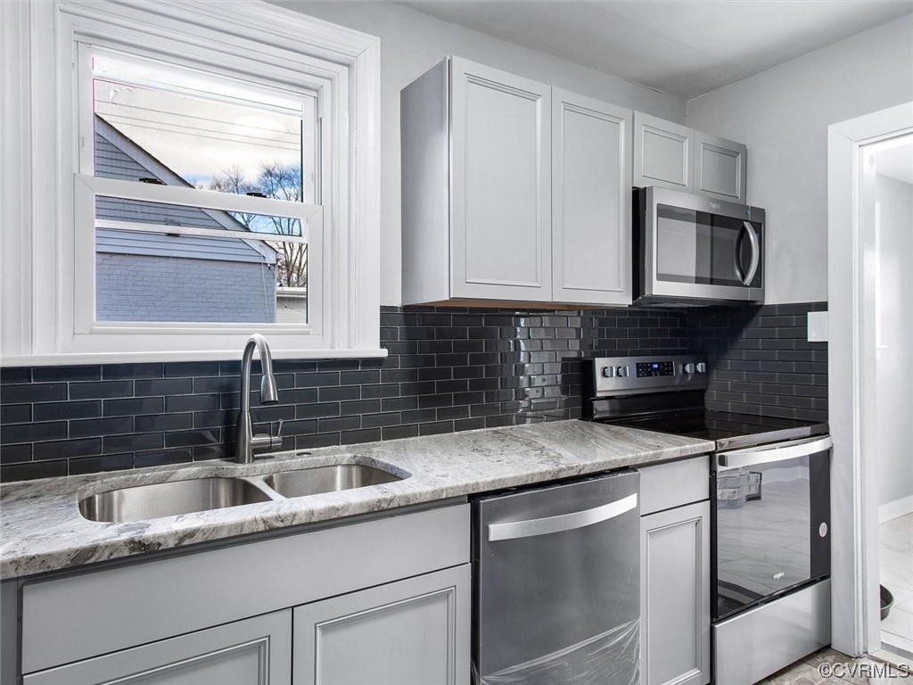 6903 Everview Road Richmond, VA 23226 - Photo 13 of 34 a kitchen with stainless steel appliances granite countertop a sink stove and microwave