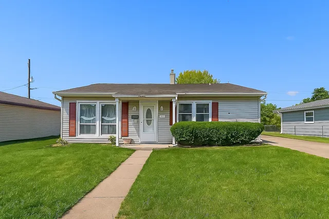 a front view of a house with a yard and potted plants