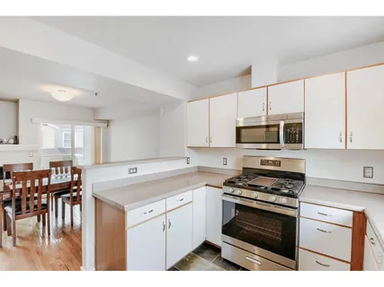 a kitchen with stainless steel appliances white cabinets and a stove top oven