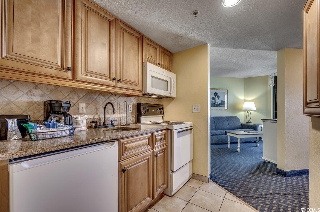 7100 North Ocean Boulevard, Unit 825 Myrtle Beach, SC 29572 - Photo 6 of 38 Kitchen with sink, light tile patterned floors, wh