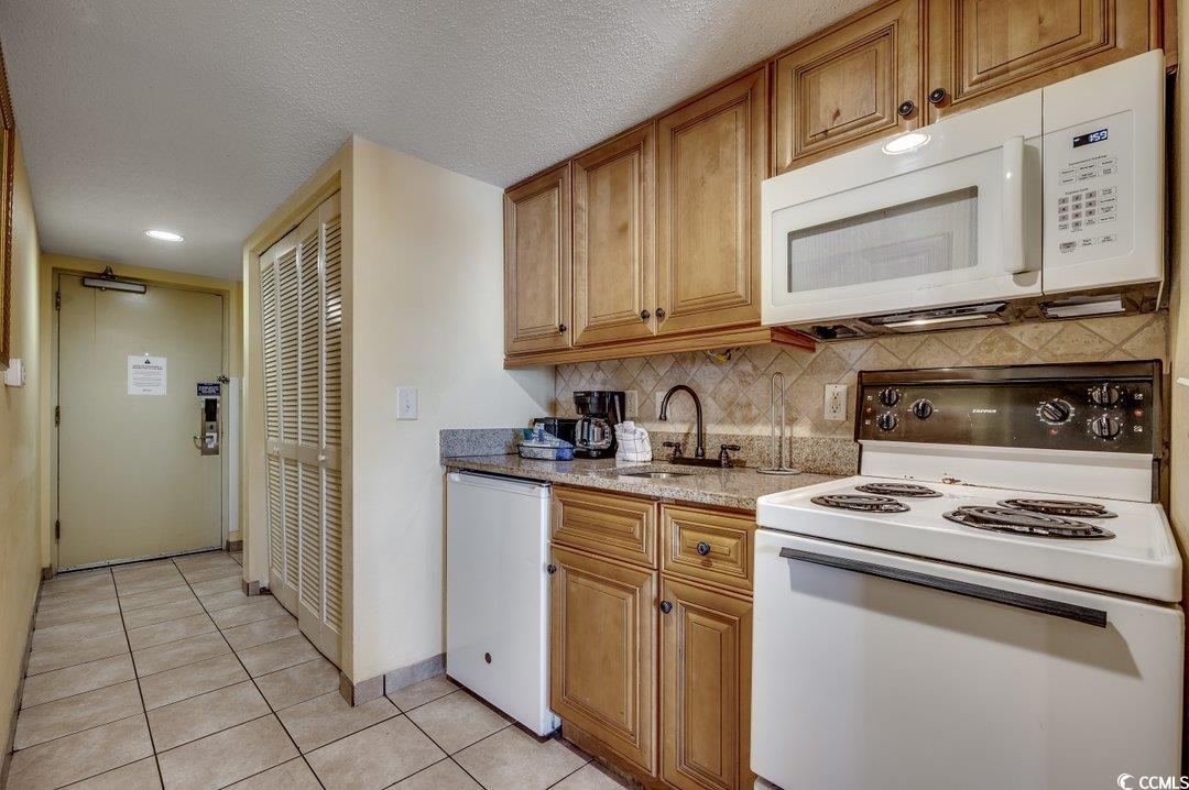 7100 North Ocean Boulevard, Unit 825 Myrtle Beach, SC 29572 - Photo 7 of 38 Kitchen with decorative backsplash, white applianc