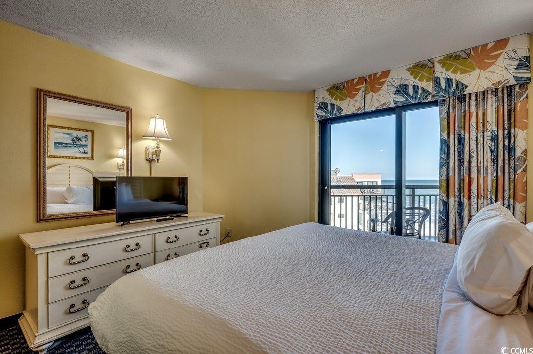 7100 North Ocean Boulevard, Unit 825 Myrtle Beach, SC 29572 - Photo 8 of 38 Bedroom featuring a textured ceiling and access to