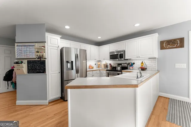 a view of kitchen with sink refrigerator and cabinets