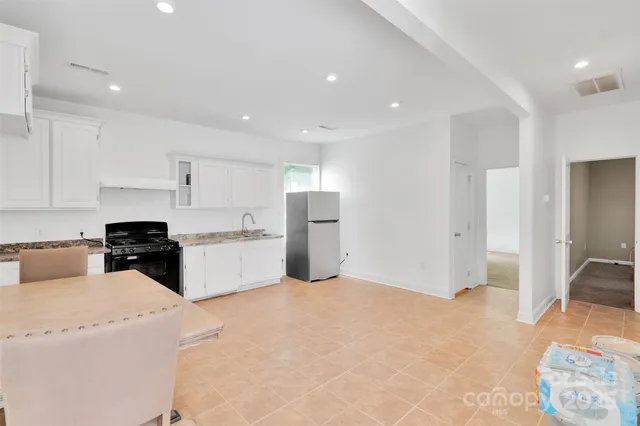 a kitchen with a refrigerator and white cabinets