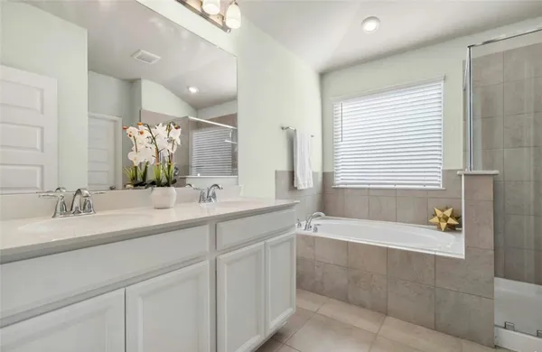 a bathroom with a bathtub a sink and a window