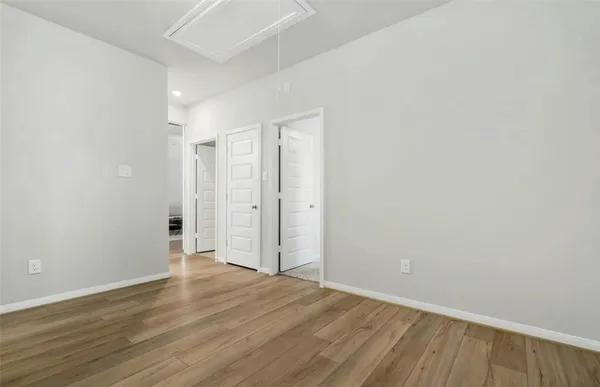 a view of an empty room with wooden floor