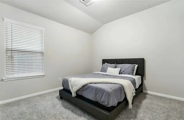 a large bed sitting in a bedroom next to a window