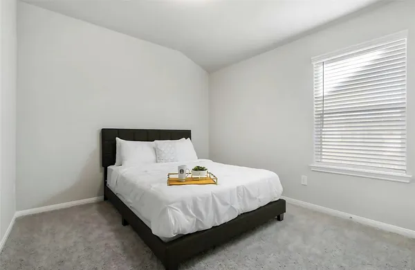 a large bed sitting in a bedroom next to a window
