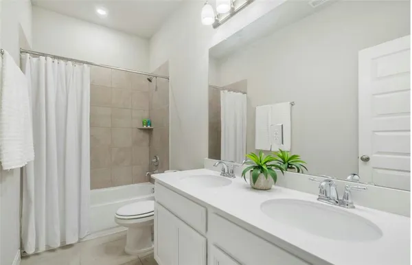 a bathroom with a granite countertop sink a toilet and shower