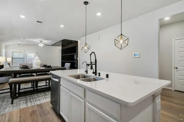 a kitchen with a sink cabinets and wooden floor