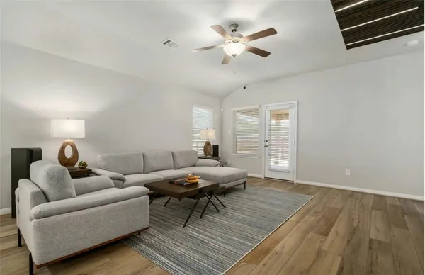 a living room with furniture and wooden floor