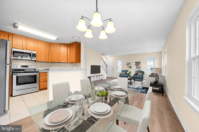 a kitchen with stainless steel appliances a stove a sink a dining table and chairs