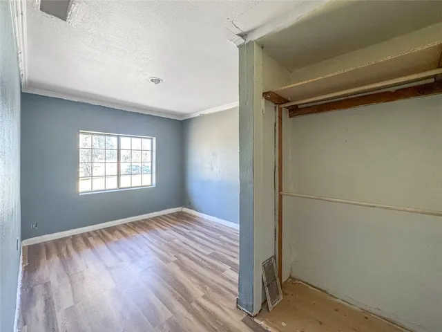 a view of empty room with window and wooden floor