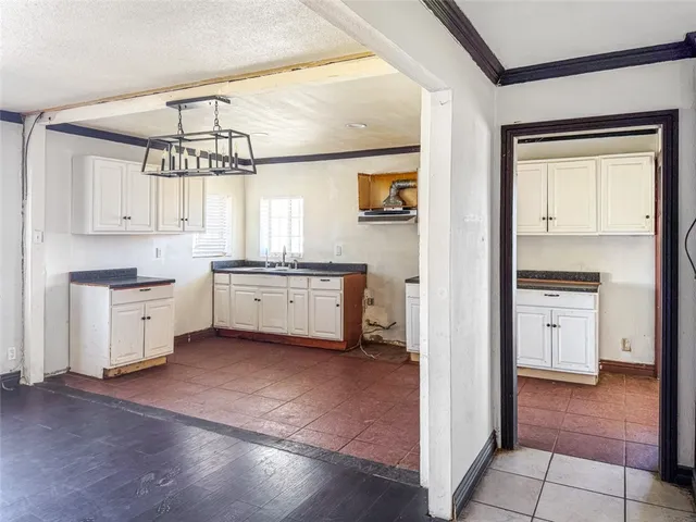 a view of a kitchen with a sink dishwasher and wooden cabinets