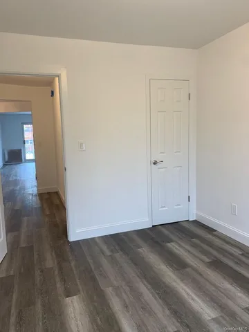 an empty room with wooden floor & windows