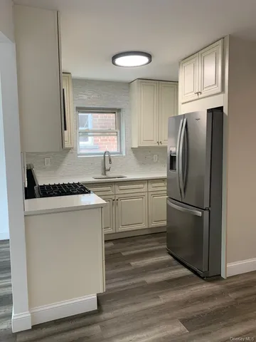 a kitchen with a refrigerator sink and cabinets