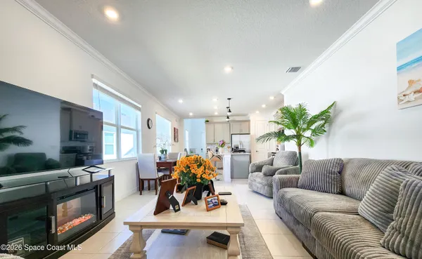 a living room with furniture kitchen view and a potted plant