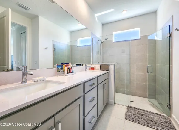a bathroom with a granite countertop shower and mirror