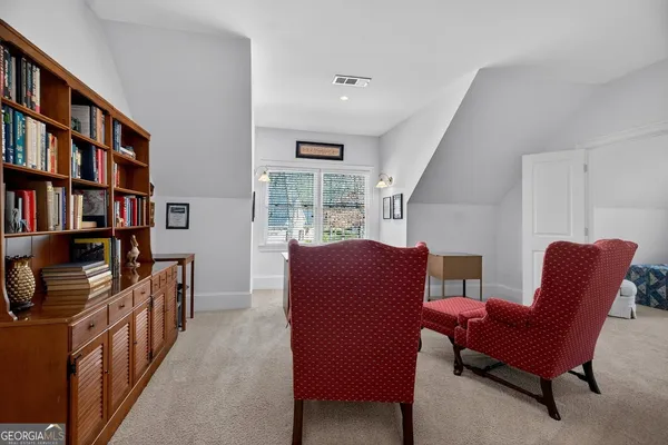 a living room with furniture a bookshelf and a window