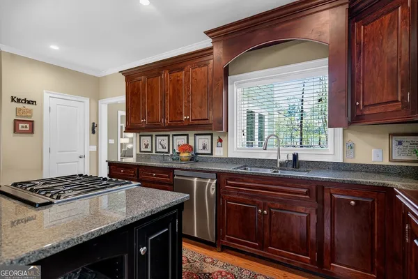 a kitchen with granite countertop a sink stove and cabinets