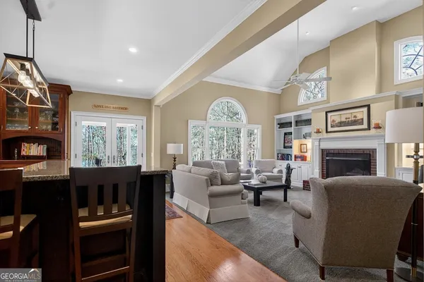 a living room with furniture fireplace and large windows