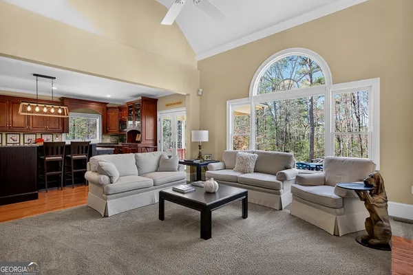 a living room with furniture a table and a large window