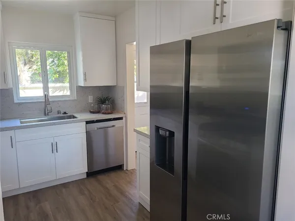 a kitchen with a refrigerator sink and cabinets