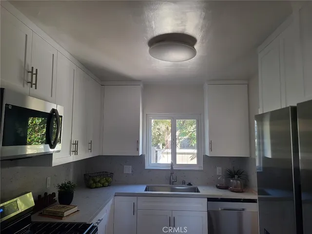 a kitchen with a refrigerator and a stove top oven