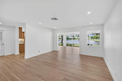 a large living room with stainless steel appliances granite countertop furniture and a large window