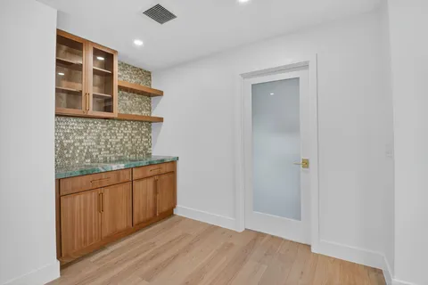 a kitchen with stainless steel appliances kitchen island granite countertop a refrigerator a sink and a wooden floors