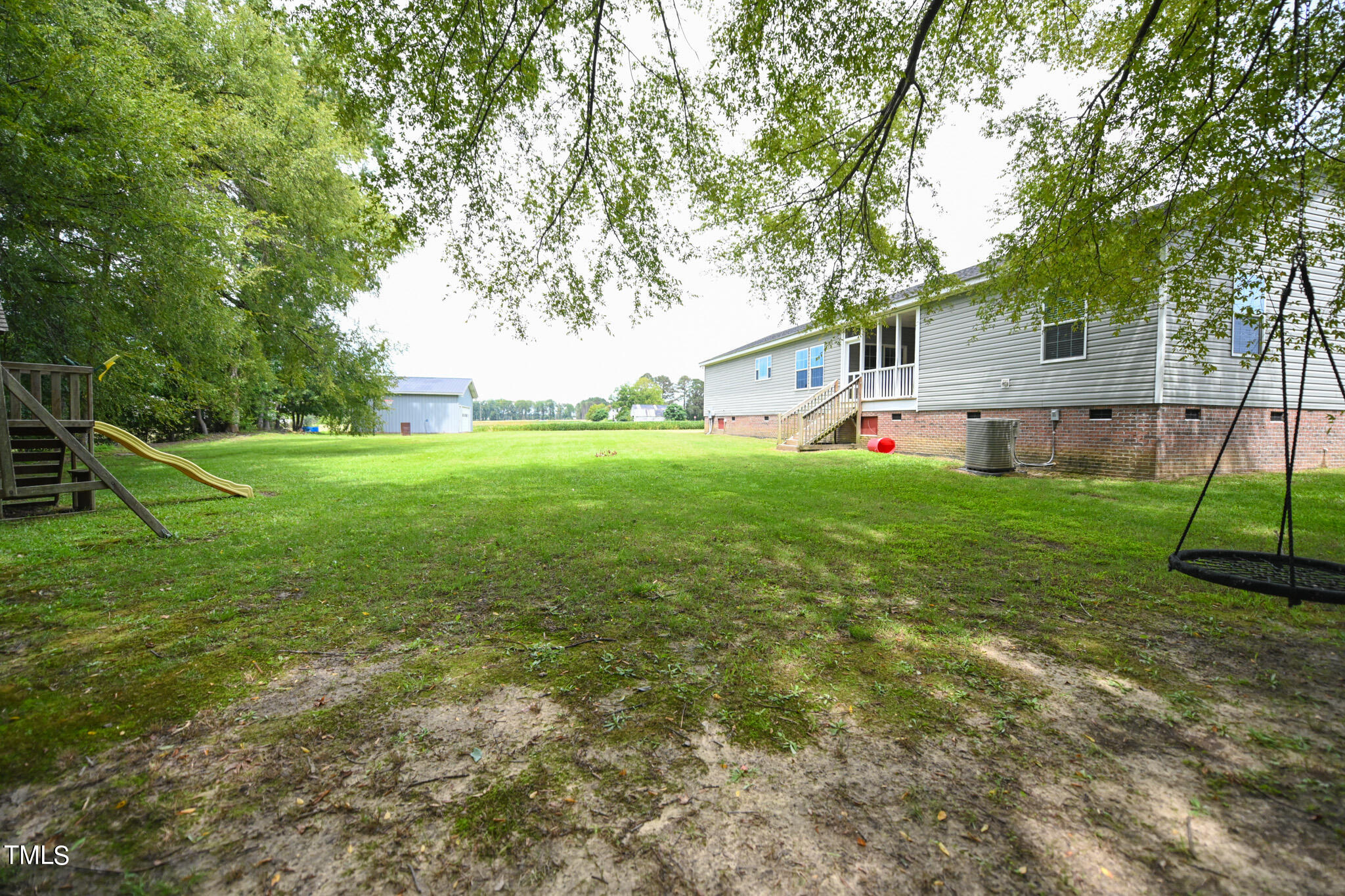 124 Evans Road Princeton, NC 27569 - Photo 39 of 44 a view of a house next to a big yard and large trees
