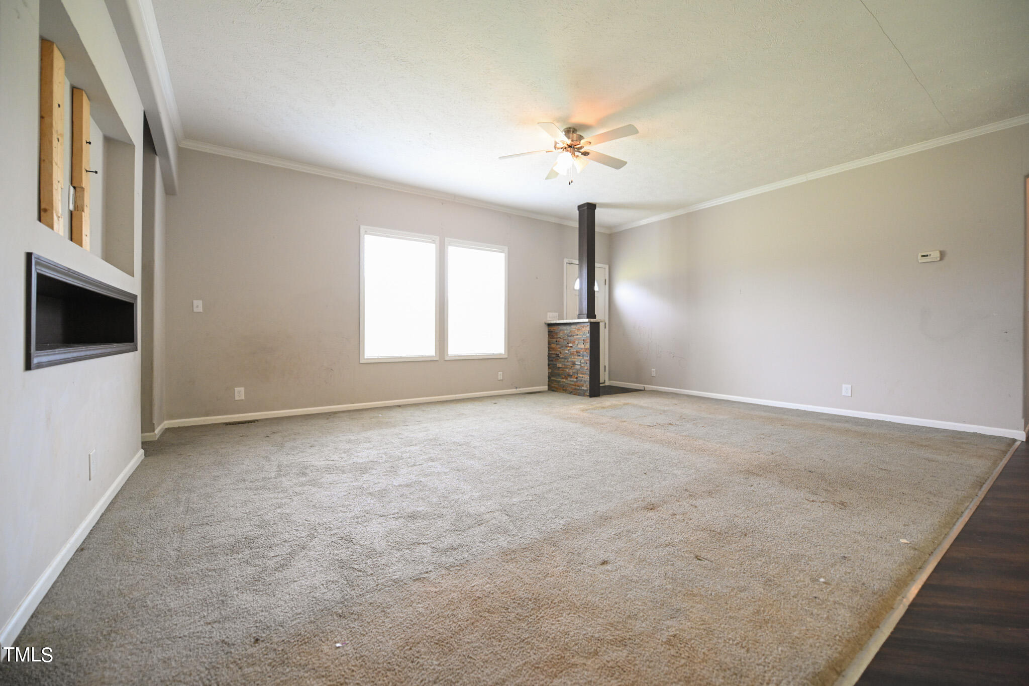 124 Evans Road Princeton, NC 27569 - Photo 7 of 44 an empty room with windows and chandelier fan