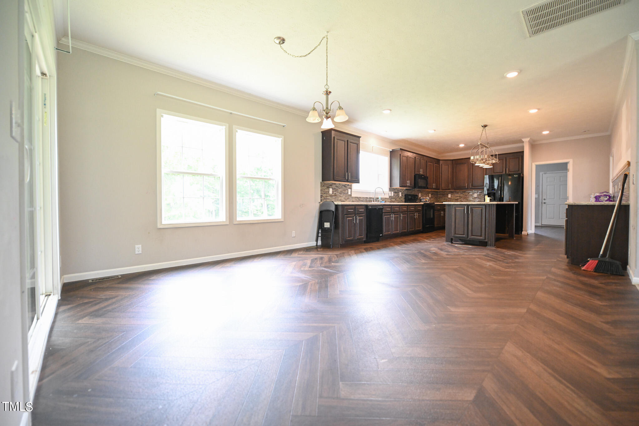124 Evans Road Princeton, NC 27569 - Photo 9 of 44 a large kitchen with kitchen island a stove a refrigerator a sink dishwasher with a dining table and chairs with wooden floor