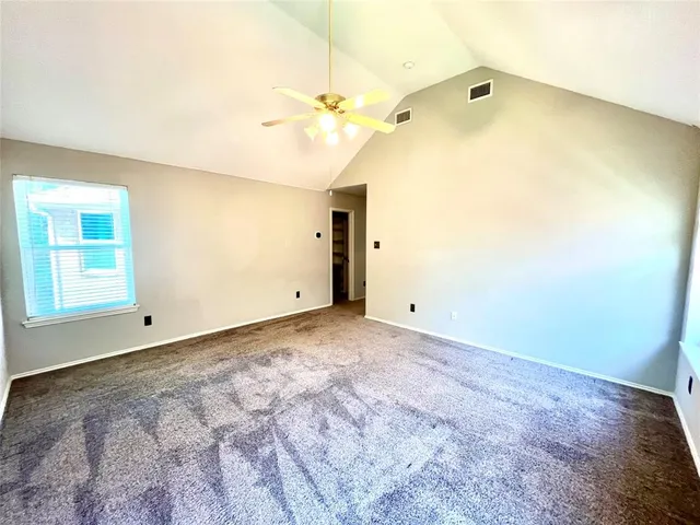 an empty room with a ceiling fan and a window